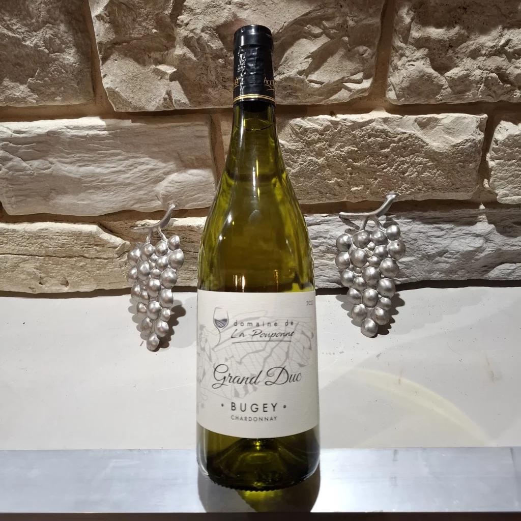 Chardonnay Grand Duc Photo d'un bouteille de vin devant un mur en pierres
