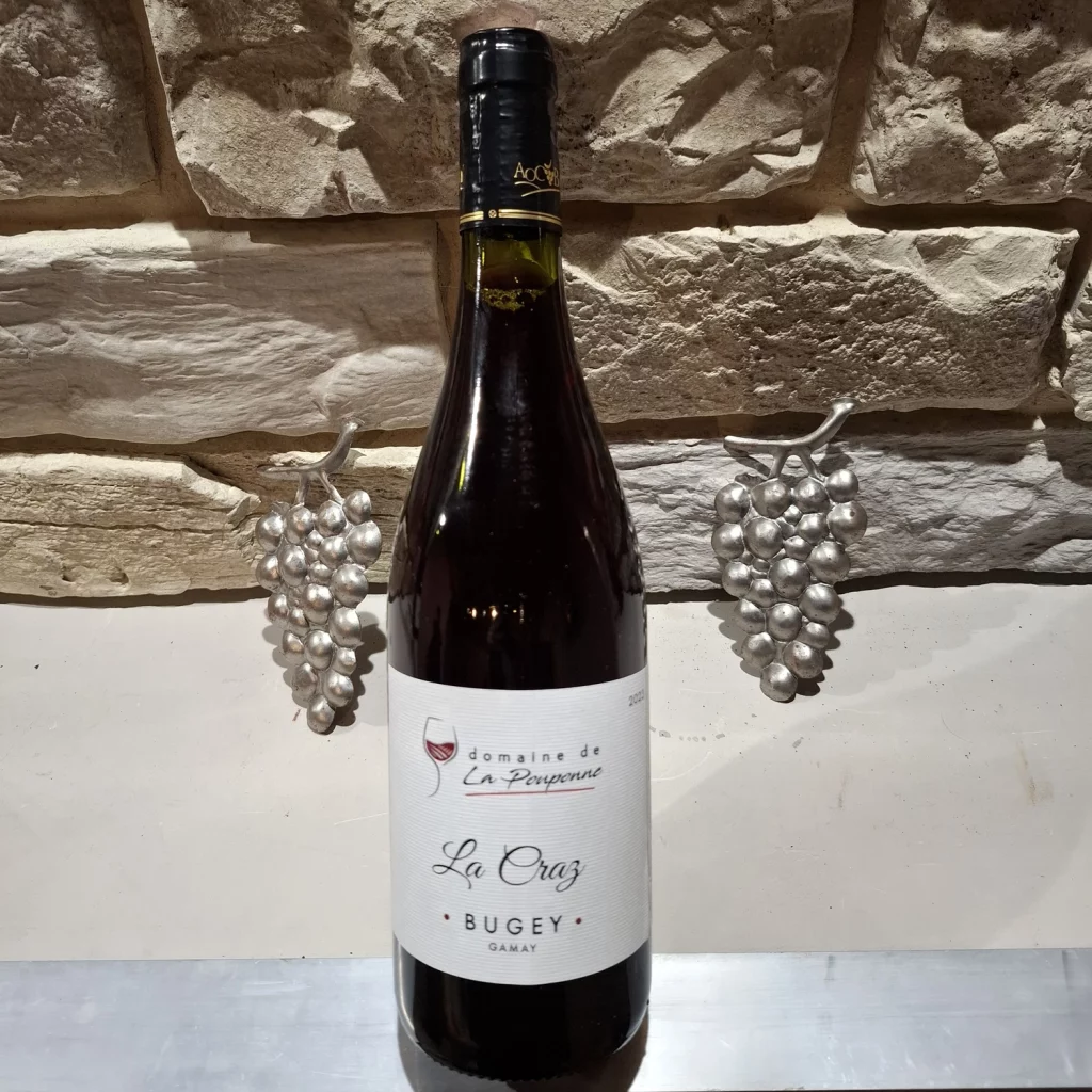 La Craz Photo d'un bouteille de vin devant un mur en pierres